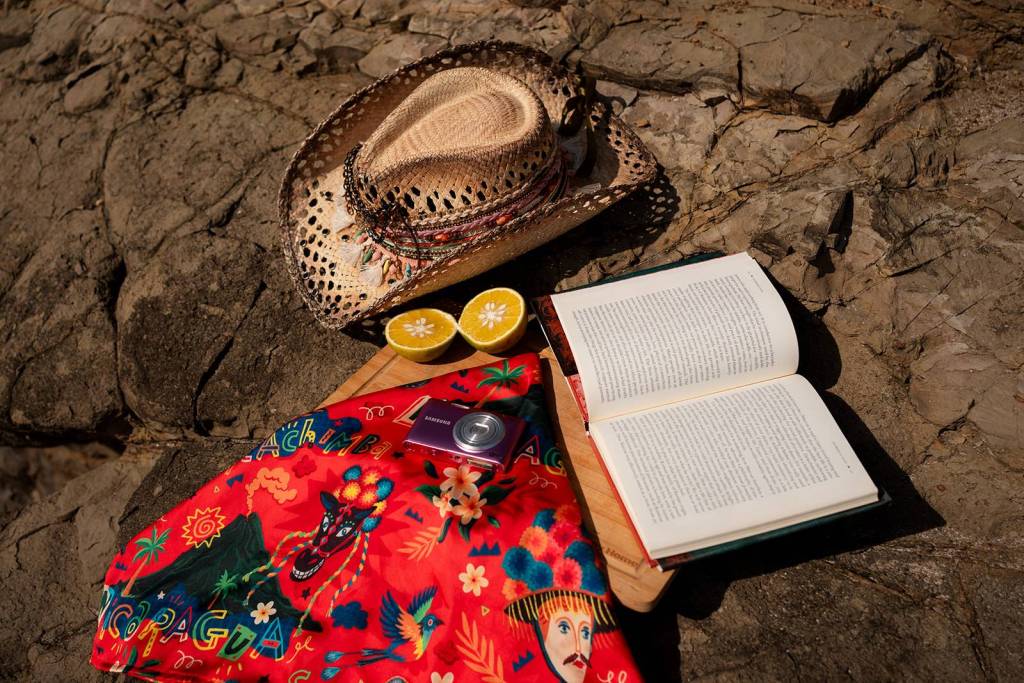 Fotografía de producto de Clase Luna en la playa: sombrero, libro, naranjas y pañuelo, por Ruah Media