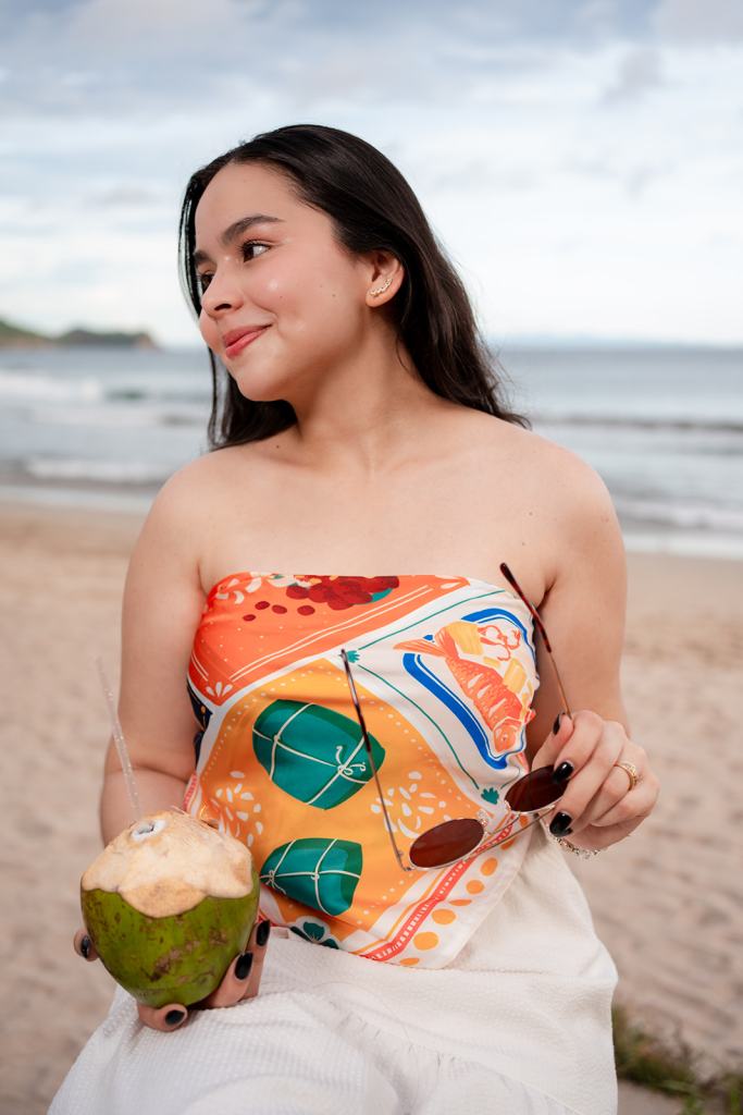 Modelo con top de pañuelo de Clase Luna y un coco en la playa, sesión de fotos en Nicaragua